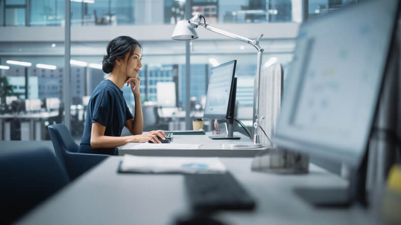 A female business manager using a desktop computer after Business Office Management Training