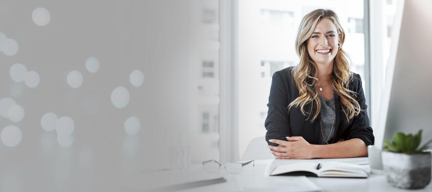 A smiling female businesswoman in her office after completing her business management and finance courses