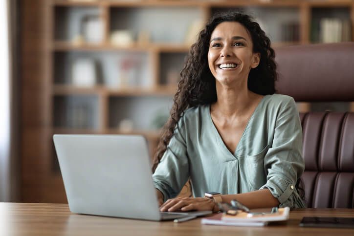 A smiling female digital marketing professional in an office after her digital marketing diploma