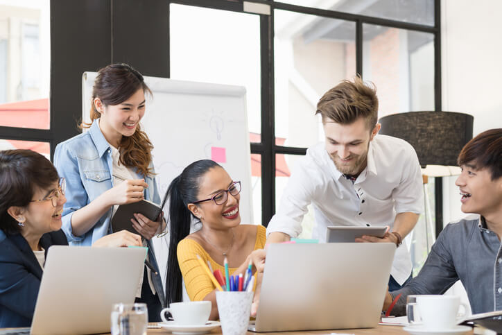 A team of digital marketing training grads collaborating on a project in an office