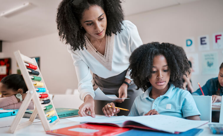 A female education assistant interacting with pupils in a classroom