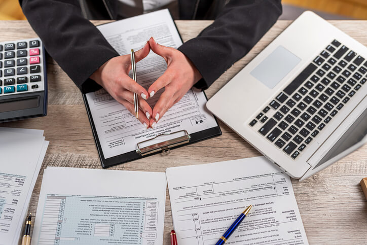 A business finance management training grad working on reports at a desk