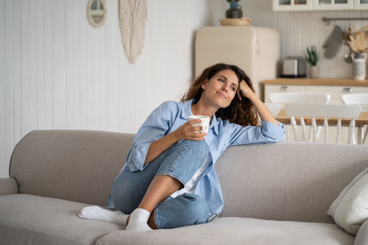 A healthcare assistant training graduate relaxing on a couch