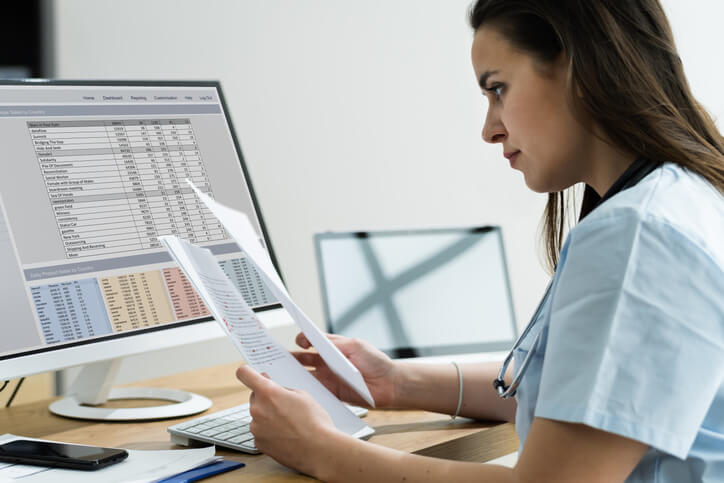 A female medical office administrator coding medical information after completing her medical office administration training