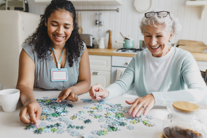 A social service worker grad doing a puzzle with a client