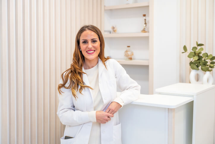 A smiling female dental assistant in an office after completing her dental office management training