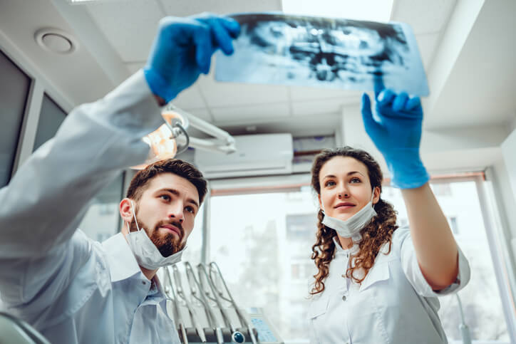 A dental radiography training grads holding up x-ray photos