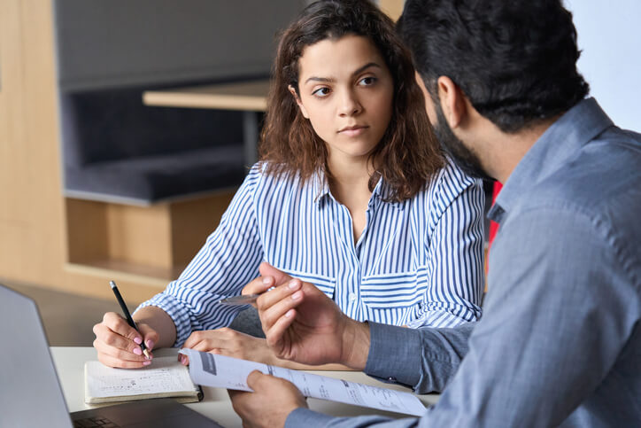 A mentor reviewing a student’s business proposal in business office management training