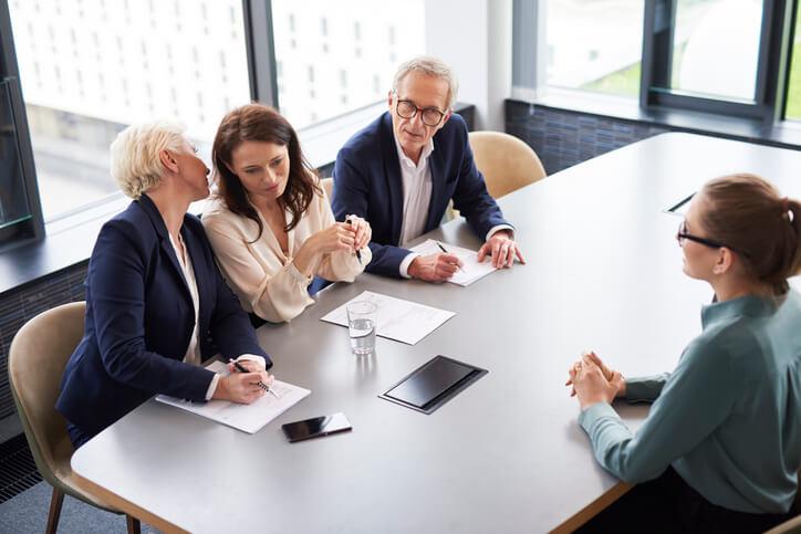 A career training grad being interviewed by three employers