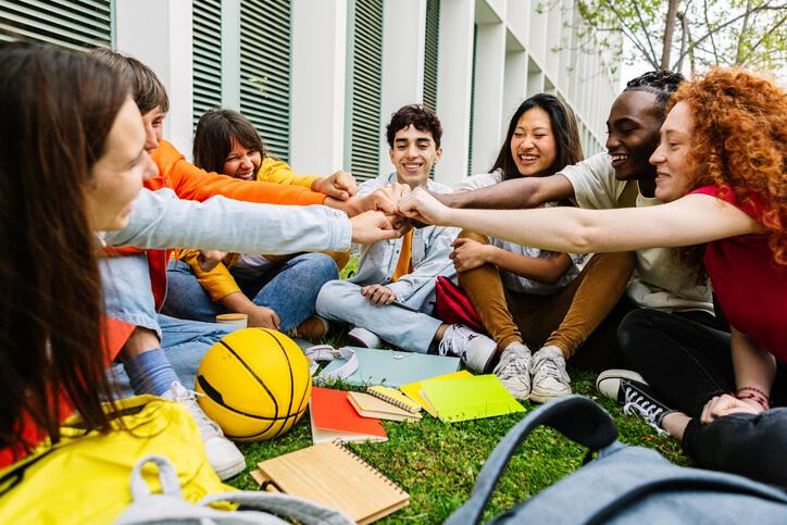 A group of career training students doing a handshake during outdoor lunch break