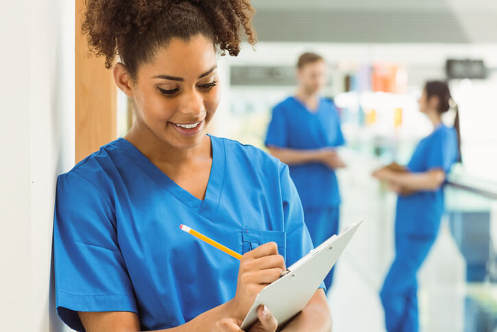 An LPN student taking notes during a practical nursing course at a nursing school