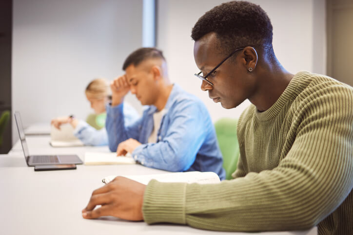 Community college student highlighting notes while studying