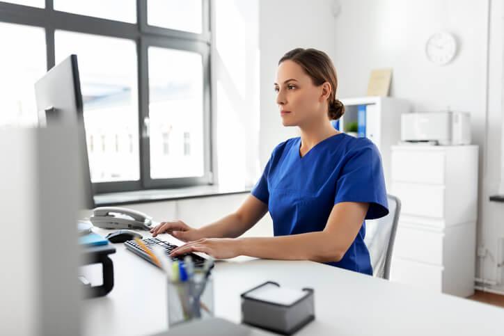 A dental reception course graduate scheduling appointments at a dental clinic