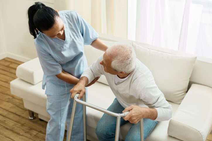 A health care assistant supporting an elderly patient in BC
