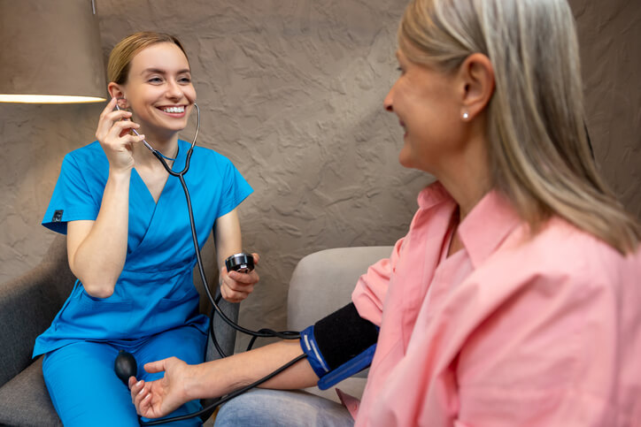 A licensed Practical Nurse taking patient vitals during a morning shift