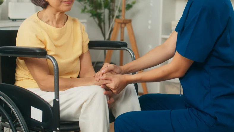 A health care assistant providing support to a senior in a care facility