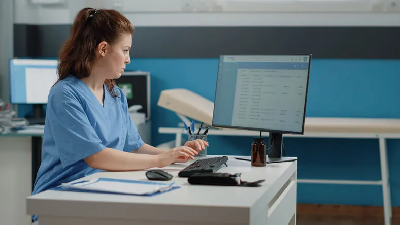 A medical dental applications graduate using an EMR system to manage patient files