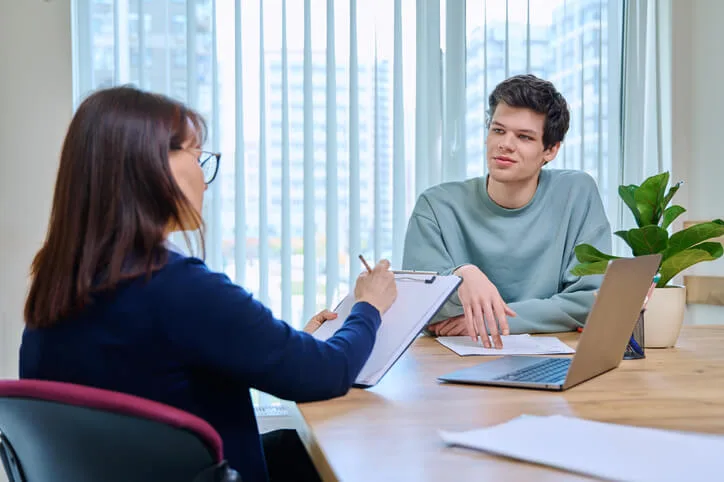 Community Support Worker vs. Social Worker: A social worker conducting a client assessment in an office setting