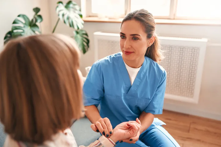 Licensed practical nurse assisting a patient with daily care.
