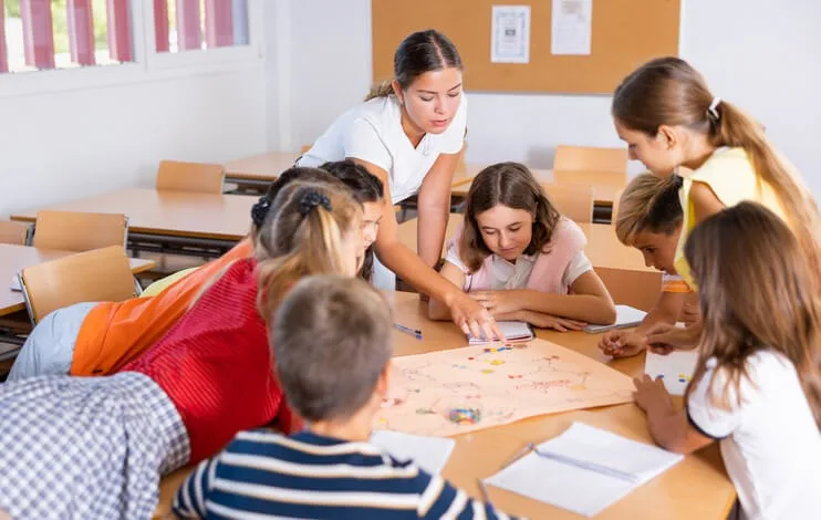 A student participating in hands-on training in a classroom setting as an educational assistant