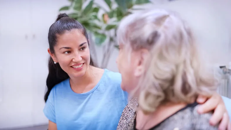 A community support worker assisting a client in a supportive care setting