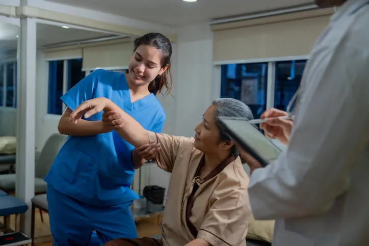 A Health Care Assistant student supports a patient during a practicum placement in BC.