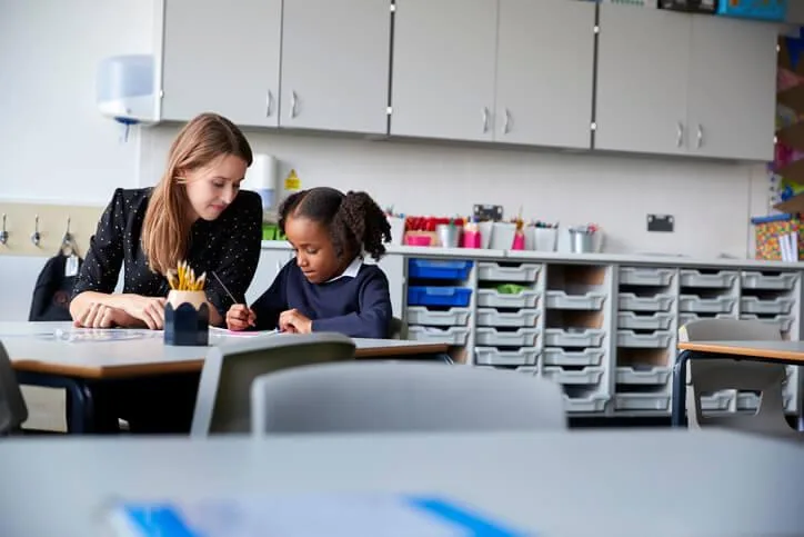 An education assistant working one-on-one with a child in a school environment