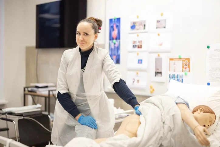 A practical nursing student practising clinical skills in a healthcare lab.