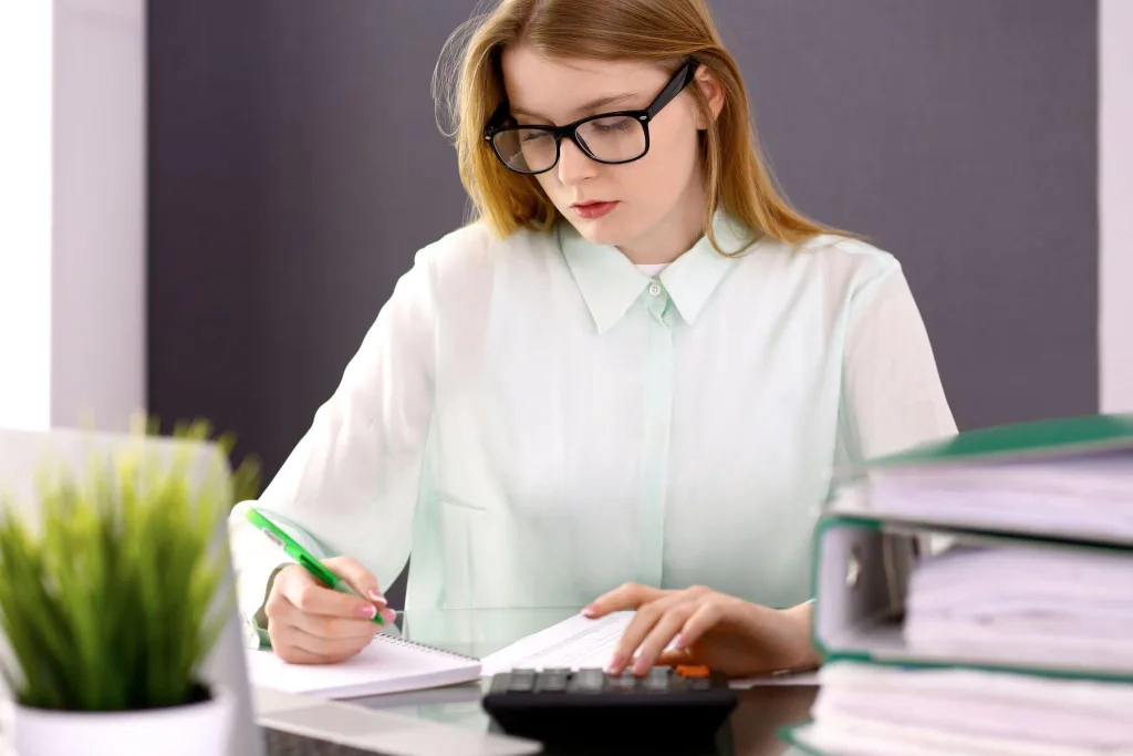 Accounting student practising manual bookkeeping procedures
